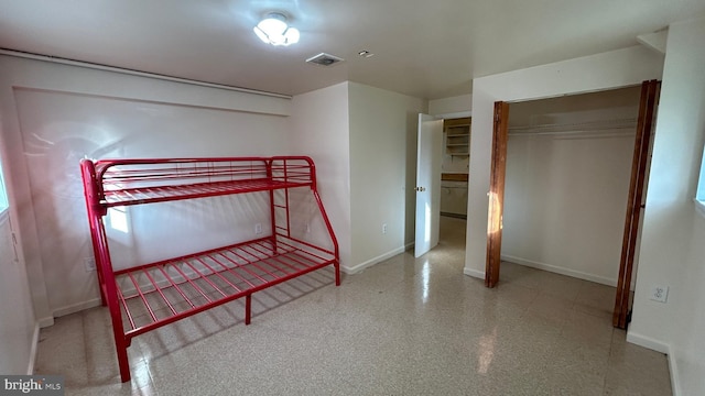 unfurnished bedroom featuring baseboards, visible vents, and a closet