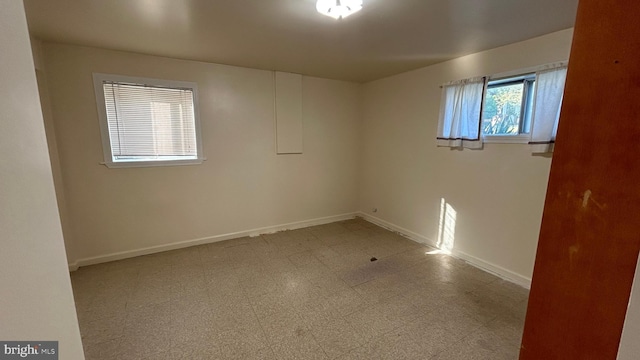 unfurnished room featuring baseboards and tile patterned floors