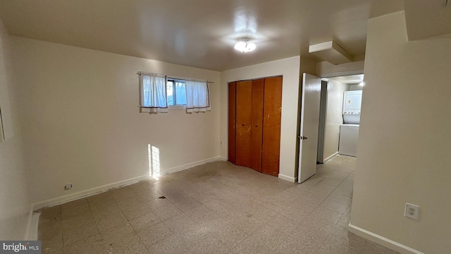 unfurnished bedroom with light floors, baseboards, and a closet