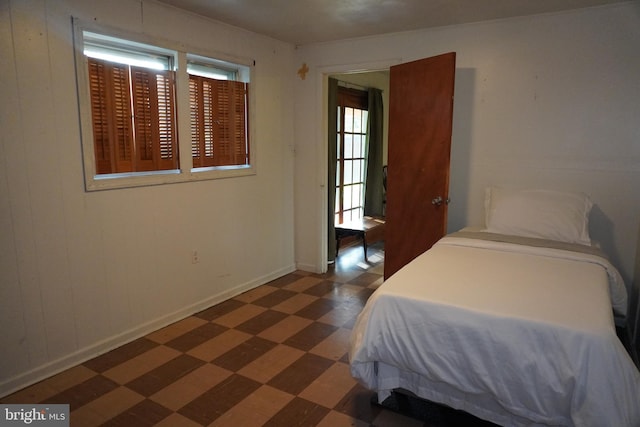 bedroom featuring dark floors, baseboards, and multiple windows