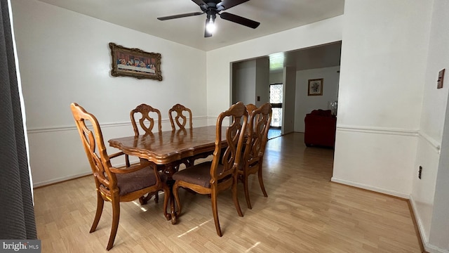 dining space featuring light wood-style flooring, baseboards, and ceiling fan