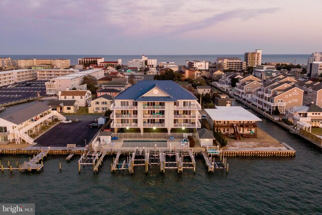 aerial view at dusk featuring a water view