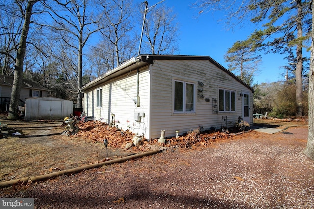 view of side of home featuring a storage shed