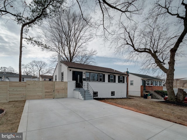 single story home featuring a chimney, fence, and a gate