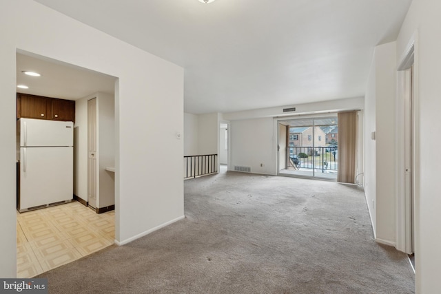 unfurnished room with light carpet, baseboards, and visible vents