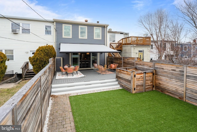 back of property featuring a fenced backyard, a lawn, and a wooden deck