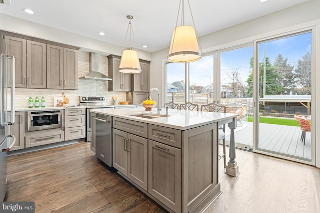 kitchen with dark wood-style flooring, stainless steel electric range oven, a sink, and wall chimney range hood