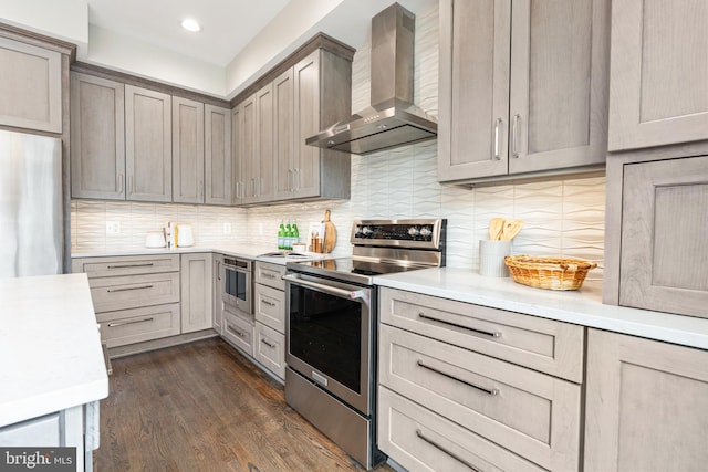 kitchen with decorative backsplash, dark wood-style flooring, stainless steel electric stove, light countertops, and wall chimney range hood