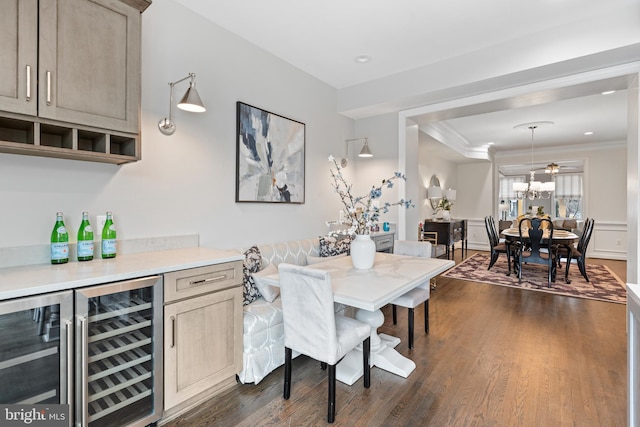 dining area with a bar, dark wood-style floors, beverage cooler, and crown molding