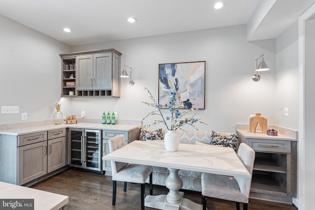 interior space featuring a bar, wine cooler, dark wood finished floors, and recessed lighting