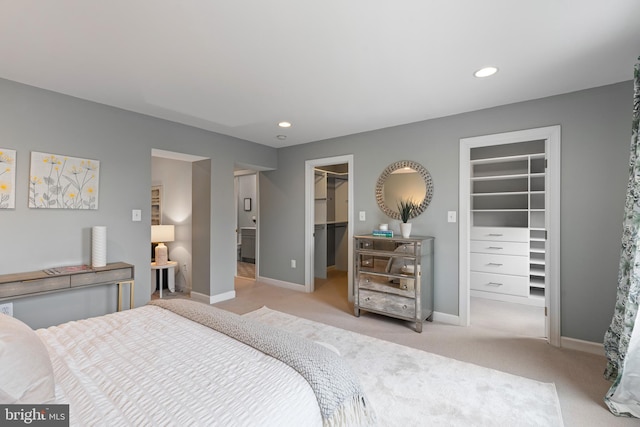 bedroom with a spacious closet, carpet floors, recessed lighting, and baseboards