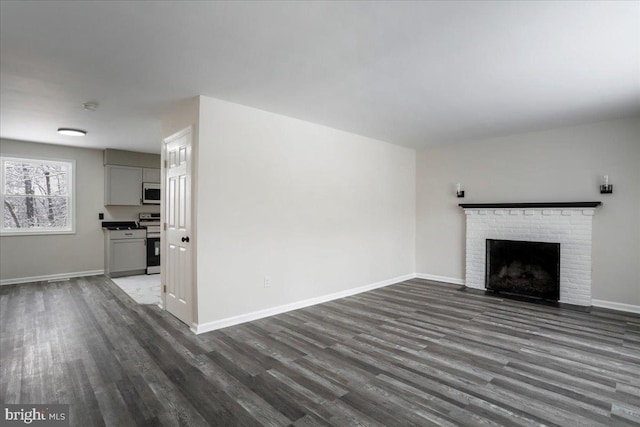 unfurnished living room featuring dark wood-type flooring and a fireplace