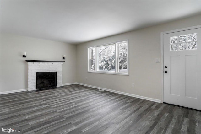 unfurnished living room featuring dark wood-type flooring and a fireplace