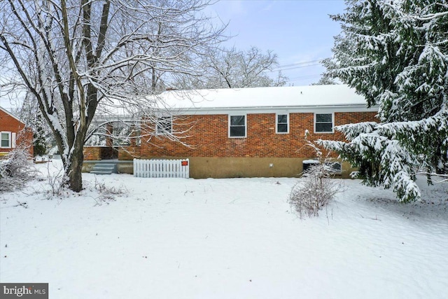 view of snow covered back of property