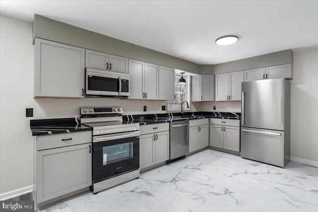 kitchen with appliances with stainless steel finishes, sink, and gray cabinetry