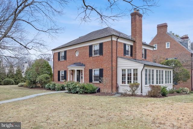 view of front facade with a sunroom and a front yard