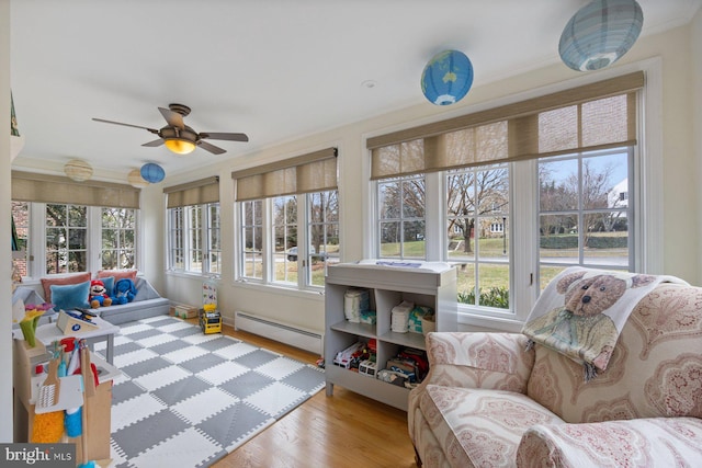 sunroom / solarium with a baseboard radiator and ceiling fan