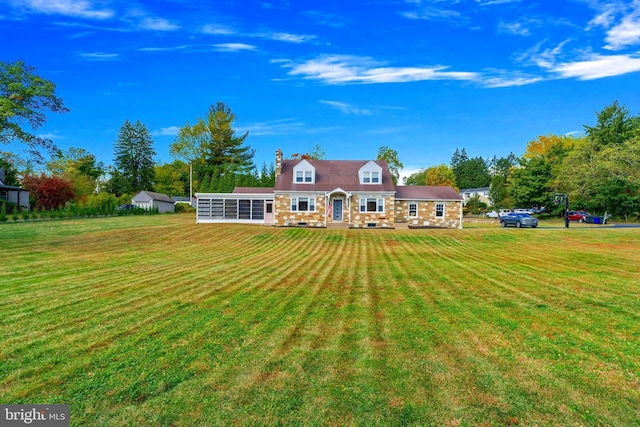 rear view of house with a sunroom and a lawn