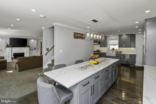 kitchen with gray cabinets, a center island, a kitchen breakfast bar, and decorative light fixtures