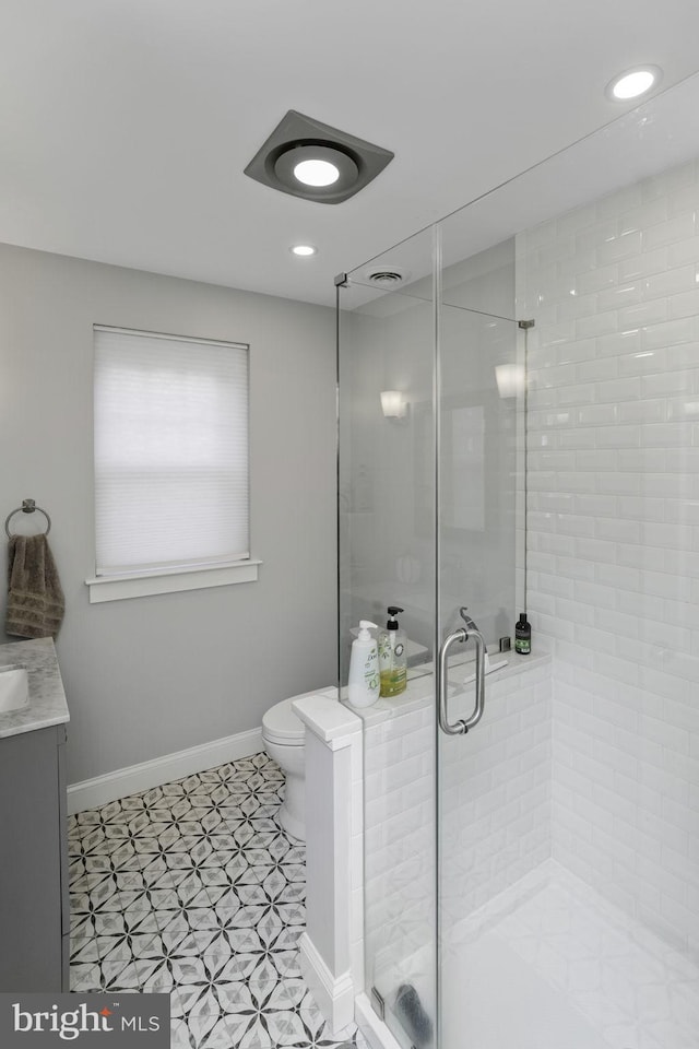 bathroom featuring an enclosed shower, vanity, and toilet