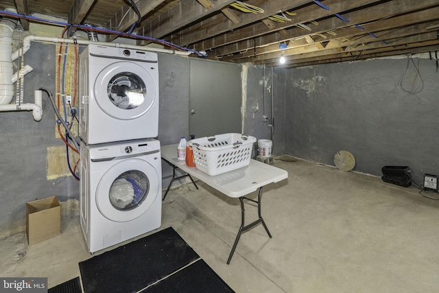 clothes washing area featuring stacked washer and dryer