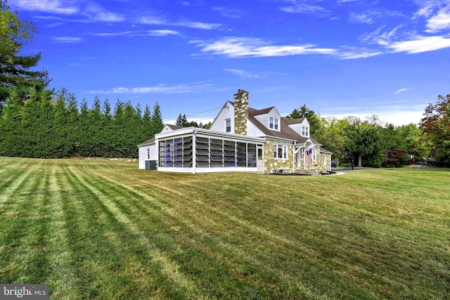 back of property with cooling unit, a yard, and a sunroom