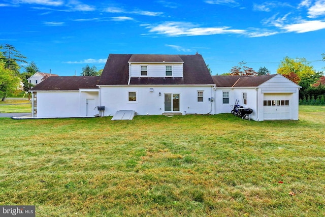 back of house featuring a garage and a lawn