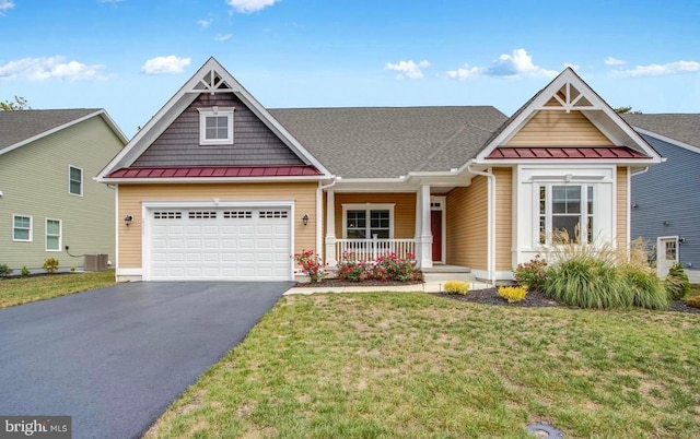 craftsman-style house with a porch, a garage, central AC unit, and a front yard