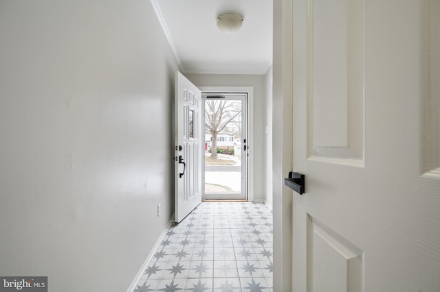 doorway to outside with light floors, baseboards, and ornamental molding