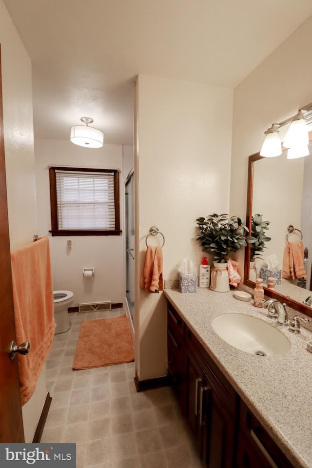 bathroom featuring vanity, toilet, and walk in shower