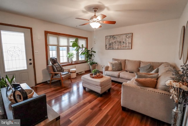 living room featuring dark wood-type flooring and ceiling fan