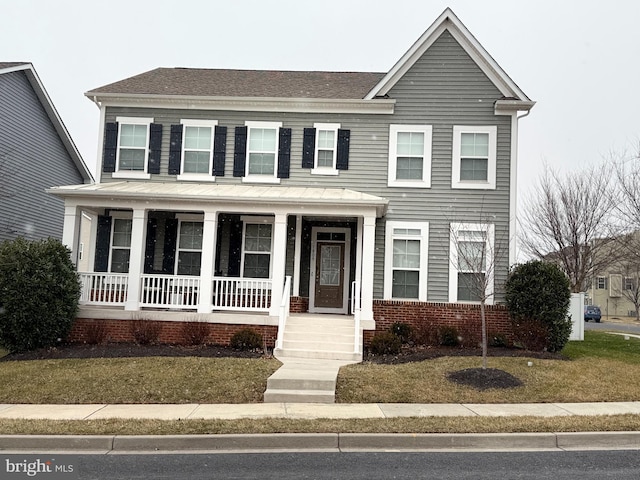 view of front of house featuring roof with shingles, a front lawn, and brick siding