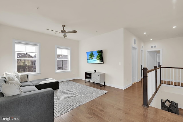 living room featuring baseboards, visible vents, a ceiling fan, wood finished floors, and recessed lighting