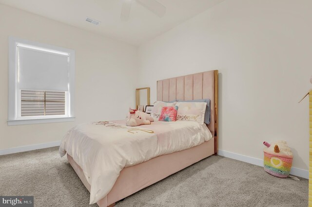 carpeted bedroom featuring a ceiling fan, visible vents, and baseboards