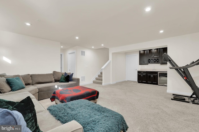 living area with wine cooler, light colored carpet, visible vents, stairway, and indoor wet bar