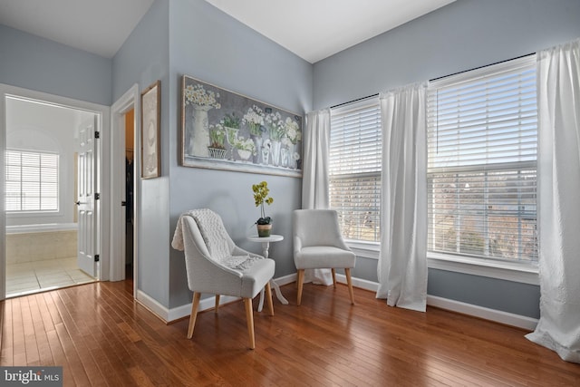 living area featuring baseboards and hardwood / wood-style flooring