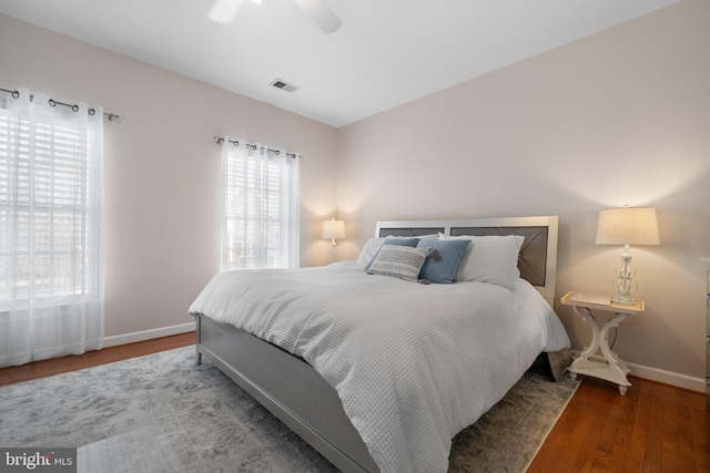 bedroom with visible vents, ceiling fan, baseboards, and wood finished floors