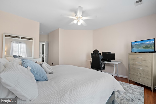 bedroom featuring dark wood finished floors, a ceiling fan, visible vents, and baseboards