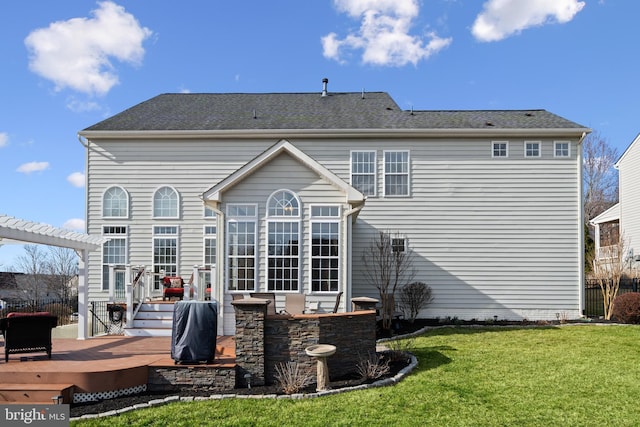 rear view of house featuring a deck, a yard, and a pergola