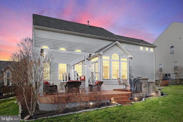 back of house with a lawn, a deck, and a pergola