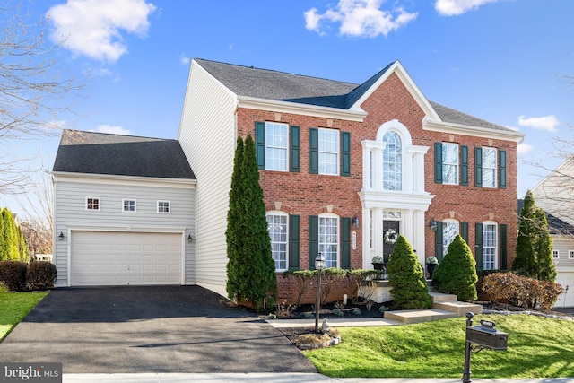 view of front of home featuring aphalt driveway, a garage, brick siding, and roof with shingles