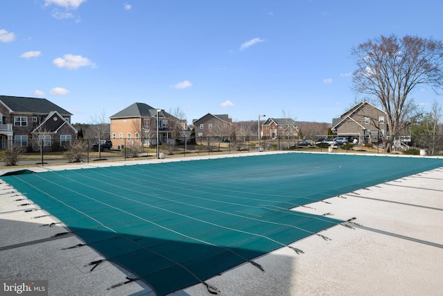 pool with a residential view and fence