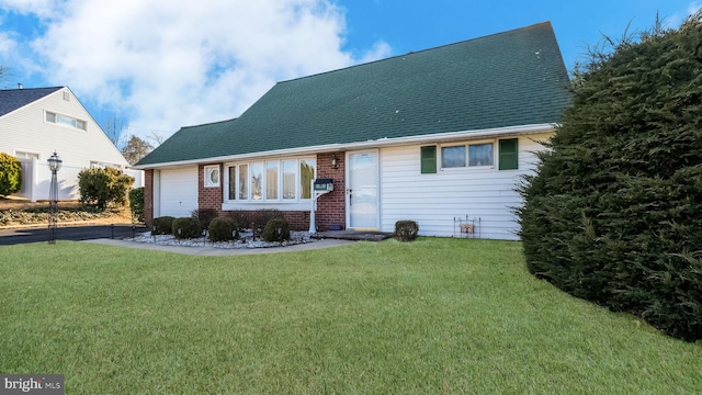 view of front of property with a garage and a front lawn