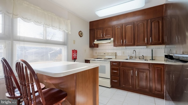 kitchen featuring a breakfast bar, white range with electric stovetop, sink, decorative backsplash, and light tile patterned floors