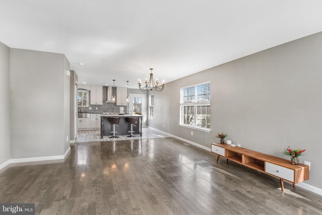 unfurnished living room featuring dark hardwood / wood-style flooring and a chandelier