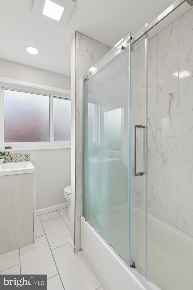 full bathroom with sink, bath / shower combo with glass door, and toilet