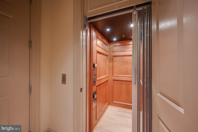 interior details with hardwood / wood-style flooring and elevator