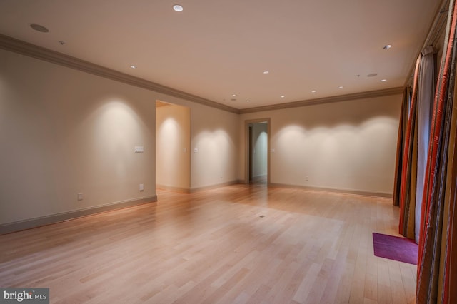 spare room with ornamental molding and light hardwood / wood-style flooring