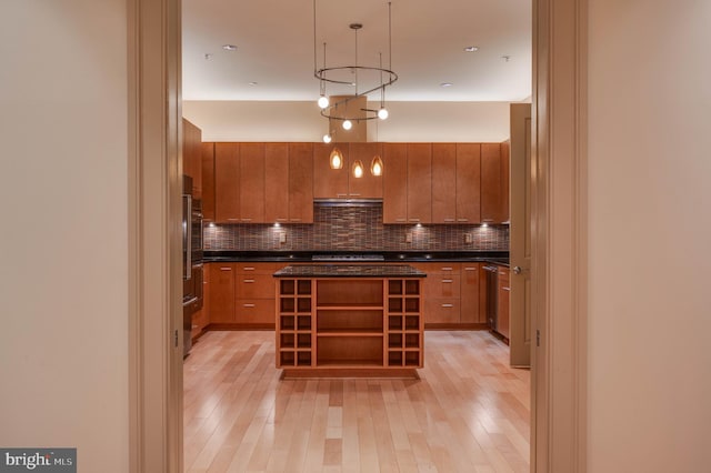 kitchen featuring tasteful backsplash, a kitchen island, light hardwood / wood-style floors, and decorative light fixtures