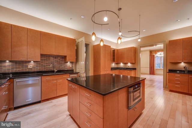 kitchen featuring a center island, appliances with stainless steel finishes, sink, and light hardwood / wood-style flooring